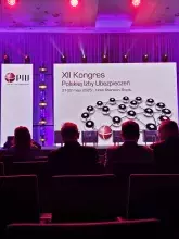 Uczestnicy XII Kongresu Polskiej Izby Ubezpieczeń siedzą na tle prezentacji