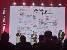 Uczestnicy XII Kongresu Polskiej Izby Ubezpieczeń siedzą na tle prezentacji